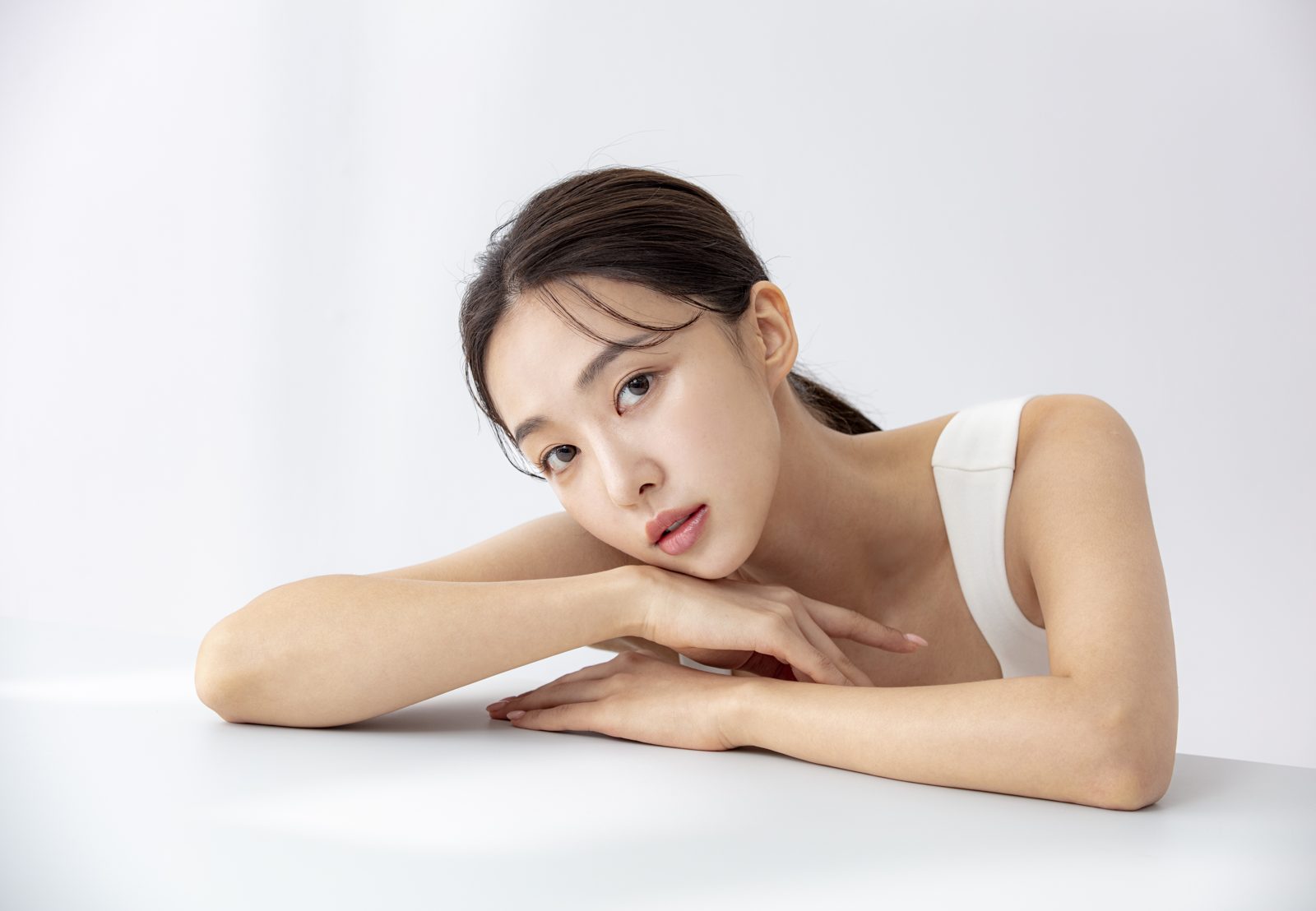 팔에 기대어 정면을 바라보는 모델